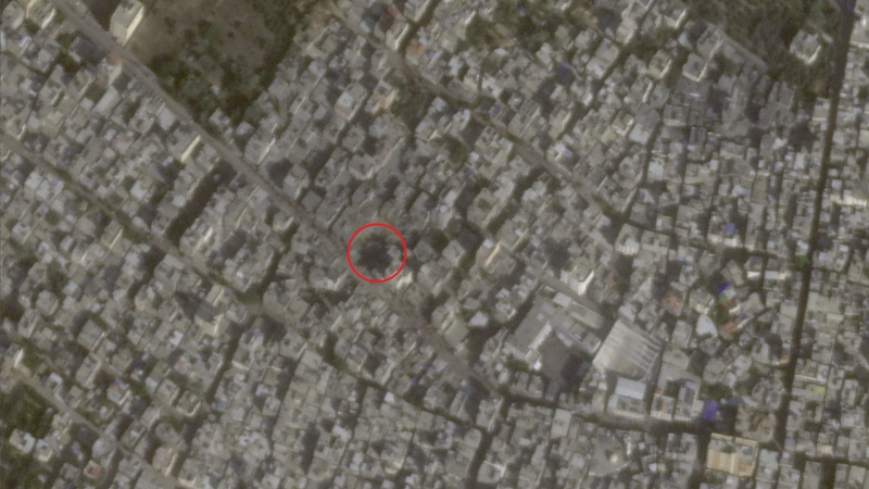 A satellite image of a dense urban area with a red circle around a crater.