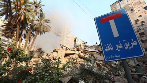 At the center of the image, a man stands atop a pile of rubble. To the right, in the foreground, is a sign that reads: "Dead end."