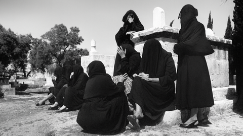 صورة من العام ١٩٥٠ لنساء يرتدين السواد ويبكين قرب ضريح في مقبرة التوانسة بحي الشجاعيّة، التي تضمّ قبورًا للشهداء والأولياء. غزة، فلسطين المحتلة. ١٩٥٠. (الأرشيف الشخصي للدكتور شكري حجازي)