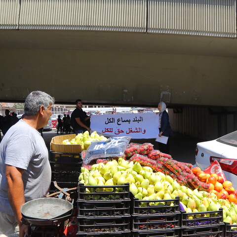 A street cart vendor passes by a protest near the Lebanese Ministry of Labor in Beirut against the crackdown on unregulated labor, July 30, 2019. (Hussein Baydoun/The Public Source)
