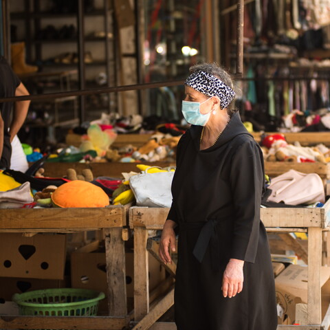 A woman donning a mask makes her way through a secondhand market in Tripoli near Nahr Abu Ali. Tripoli, Lebanon. June 13, 2020. (Natheer Halawani/The Public Source)