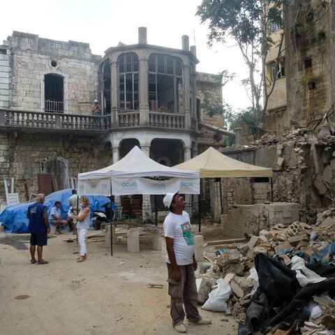 An old building stands before the ruins, aid and construction workers nearby. Karantina, Beirut. September 23, 2020. (Rita Kabalan/The Public Source)