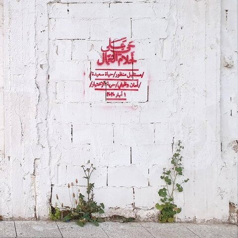 رسمة ستنسيل على حائط من عمل التجمع الفنّي "بالمرصاد" تحتوي هذه العبارة: "حيّ على أحلام العمّال. مستقبل منظور. حياة سعيدة. أمان وظيفي. حرية الاختيار". بيروت، لبنان. ١ أيّار ٢٠٢٠ (بالمرصاد)