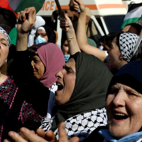 Kuffiyeh-clad women wave the Palestinian flag, raise their fists, and chant during a march from the Mar Elias refugee camp to downtown Beirut. Riad el-Solh Square, Lebanon. May 18, 2021 (Marwan Tahtah/The Public Source)