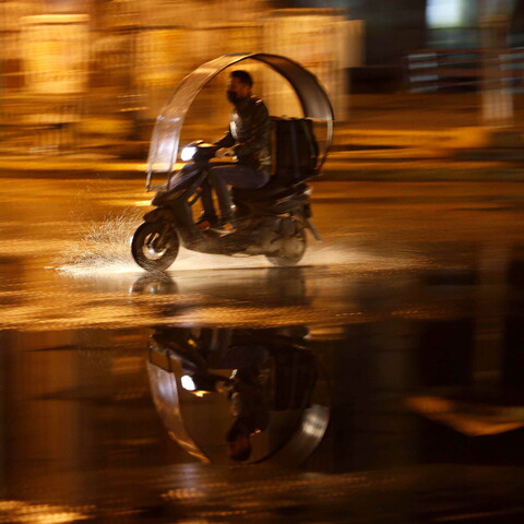 Delivery driver on the go on a rainy night.