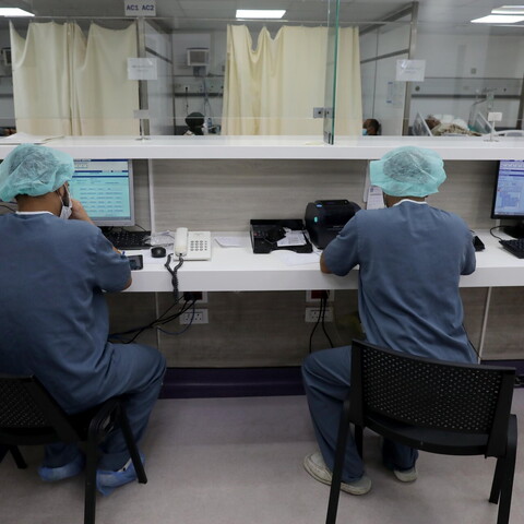 Two staff members work at their desks.