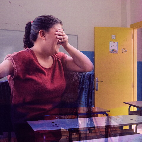 A composite of two images: a girl covering her eyes and looking away with a shy smile on her face in the foreground, with a classroom in the background.