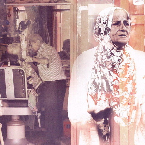 A composite of a senior woman protesting during the October 2019 uprising in the foreground against an old Mar Mkhayel barber shop in the background.