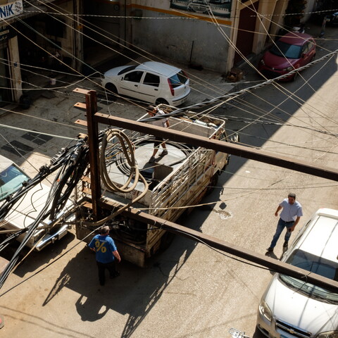 Intertwined electricity and generator cables hang close to the balcony of an apartment in the industrial zone of Beirut