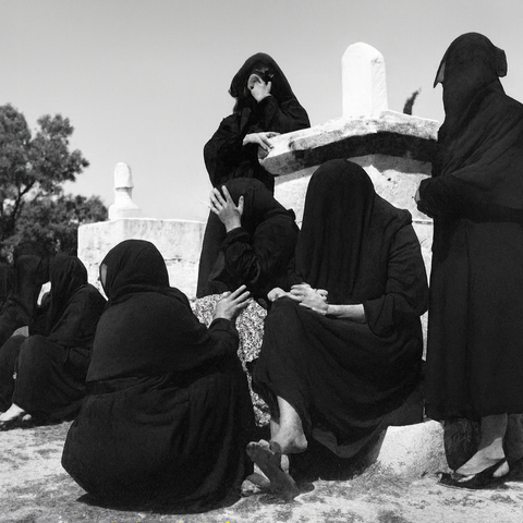 صورة من العام ١٩٥٠ لنساء يرتدين السواد ويبكين قرب ضريح في مقبرة التوانسة بحي الشجاعيّة، التي تضمّ قبورًا للشهداء والأولياء. غزة، فلسطين المحتلة. ١٩٥٠. (الأرشيف الشخصي للدكتور شكري حجازي)