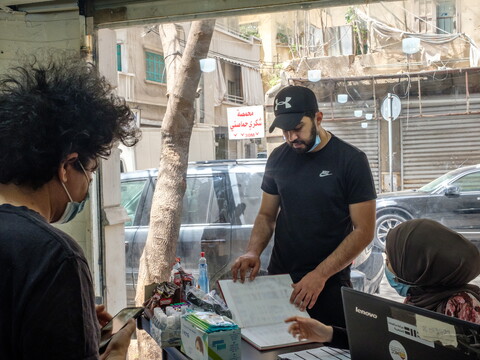 محمّد، ونادين، ونور يطالعون قائمة أعضاء التعاونية. ٣٠ نيسان، ٢٠٢١. (ريتا قبلان، مصدر عام)