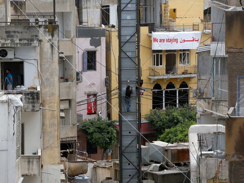 A “We are staying” banner hangs from the balcony of a destroyed building in Mar Mikhael. August 2020. (Marwan Tahtah/The Public Source)