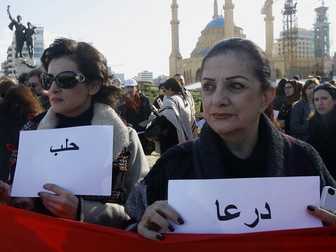 Two women hold vigil for the cities of Dara‘a and Aleppo during the one-year commemoration of the Syrian uprising. Martyrs’ Square, Beirut, Lebanon. March 17, 2012. (Marwan Tahtah/The Public Source)