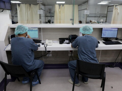 Two staff members work at their desks.