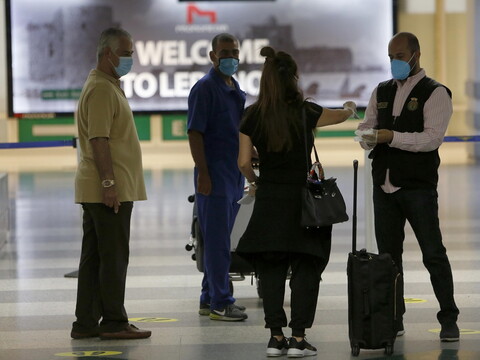 A traveler shows a travel document to a customs officer at the airport