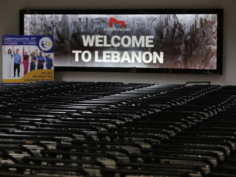 Stack of trollies in front of a sign that reads “Welcome to Lebanon”  at the Beirut International Airport.