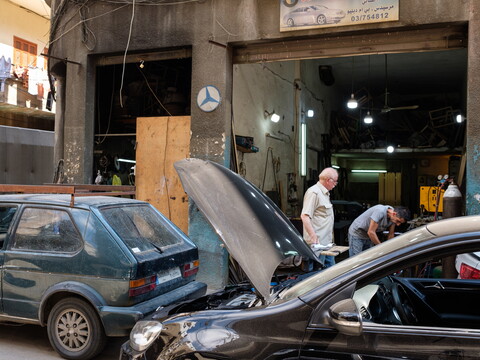 A car in repair parked outside a mechanic shop