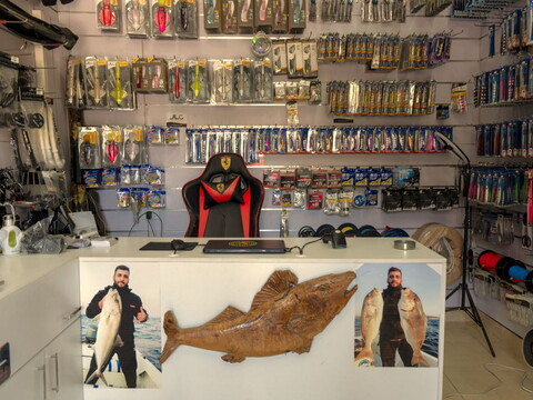 An empty store in Maaroub, Lebanon. The walls are lined with fishing equipment like hooks and bait. 