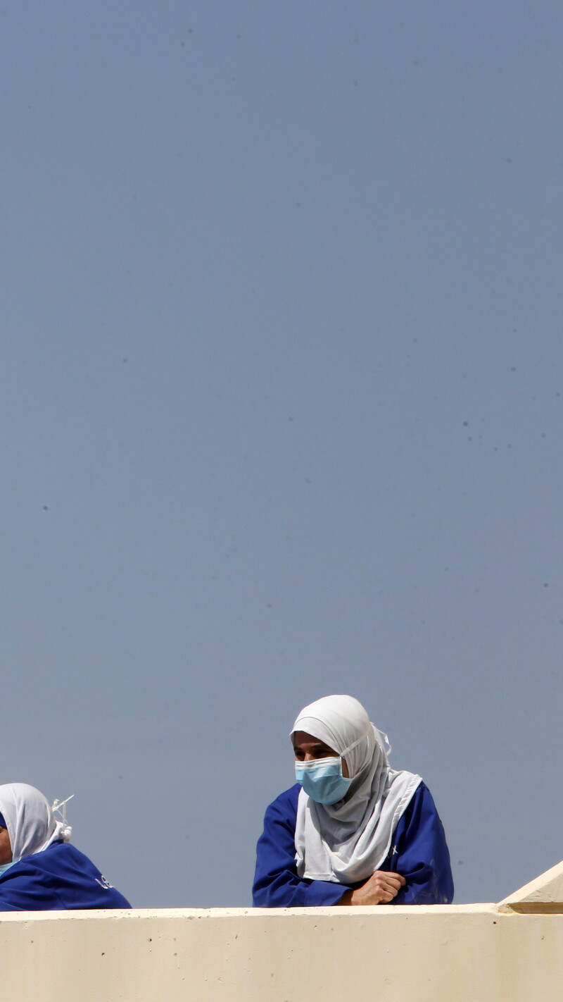 Healthcare workers take a break outside Rafik Hariri University Hospital. Beirut, Lebanon. April 17, 2020. (Marwan Tahtah/The Public Source)