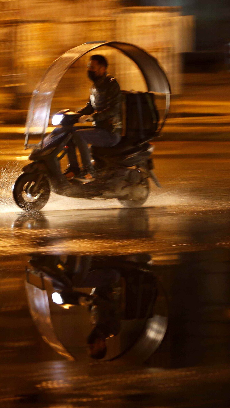 Delivery driver on the go on a rainy night.