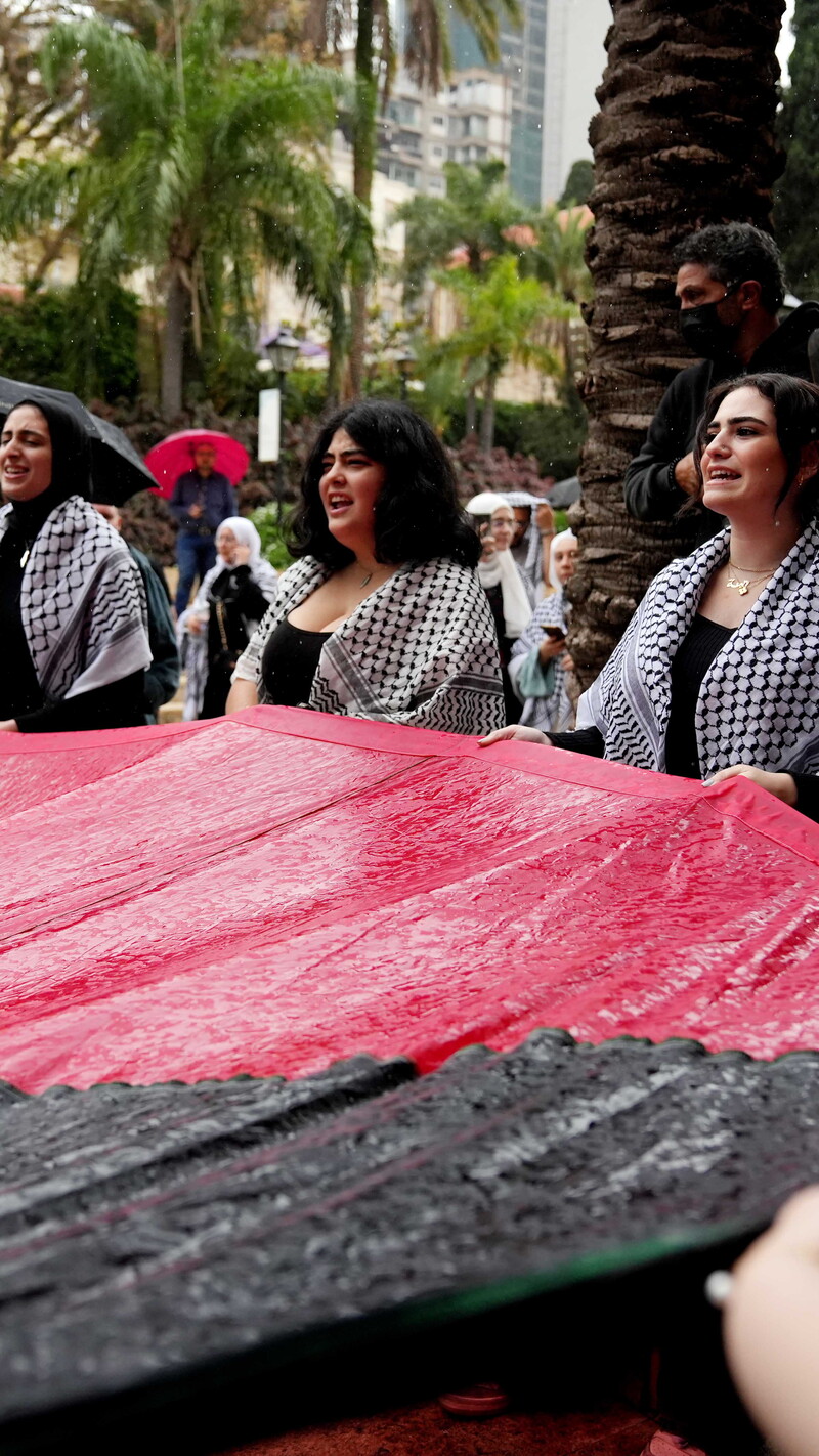 Student protesters hold a large Palestinian flag