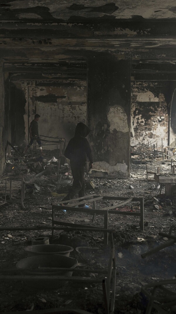 Children walk through the charred remains of what was once a school.