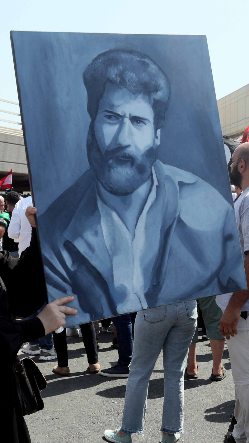 A woman holds a painting of former political prisoner Georges Abdallah outside of the Rafik Hariri Airport in Beirut, Lebanon.