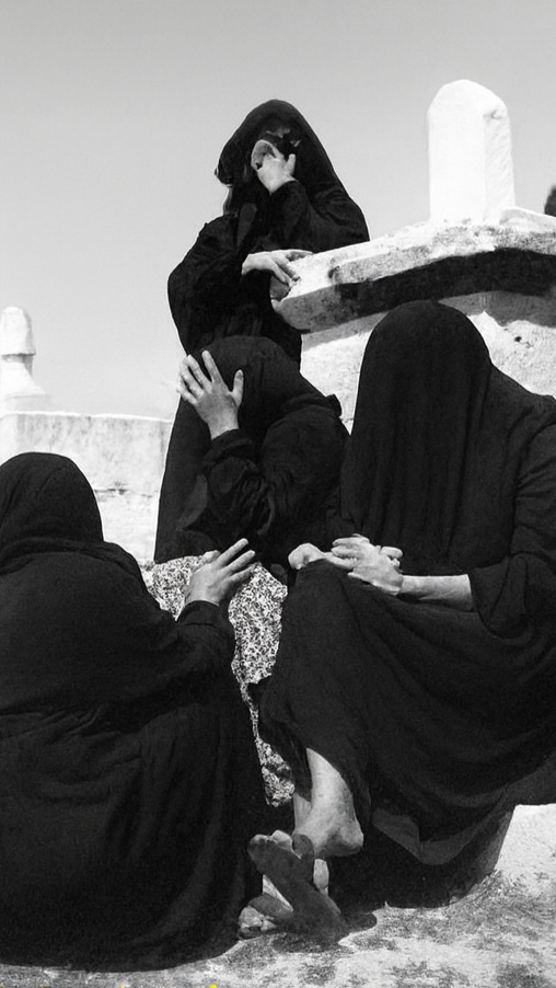 صورة من العام ١٩٥٠ لنساء يرتدين السواد ويبكين قرب ضريح في مقبرة التوانسة بحي الشجاعيّة، التي تضمّ قبورًا للشهداء والأولياء. غزة، فلسطين المحتلة. ١٩٥٠. (الأرشيف الشخصي للدكتور شكري حجازي)