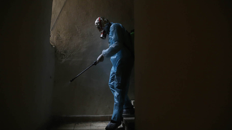 A volunteer health worker disinfects a building in Ras Beirut. Beirut, Lebanon. March 20, 2020. (Hussein Baydoun/The Public Source)