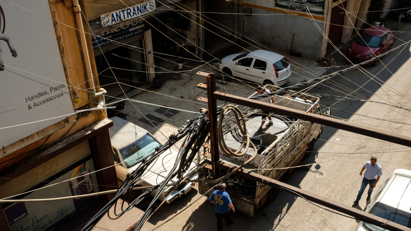 Intertwined electricity and generator cables hang close to the balcony of an apartment in the industrial zone of Beirut
