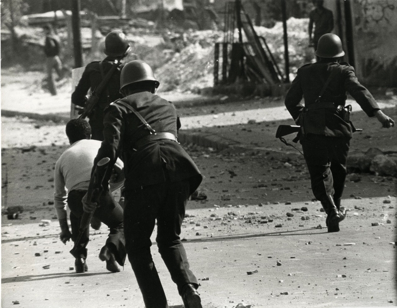 ثلاثة عناصر من العسكر أثناء مطاردتهم الطلاب في الشوارع بالحجارة والبواريد.
