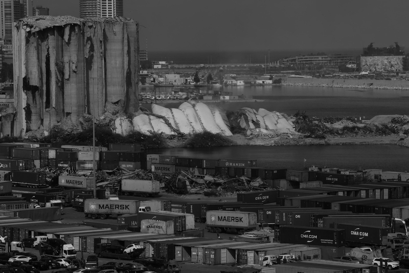 A black and white images of the Beirut port silos. The Northern block is collapsed while the Southern part still stands.