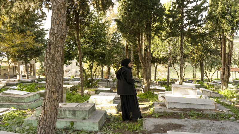 A young woman standing in the middle of Houla's cemetery. March 6, 2024. Houla, South Lebanon.