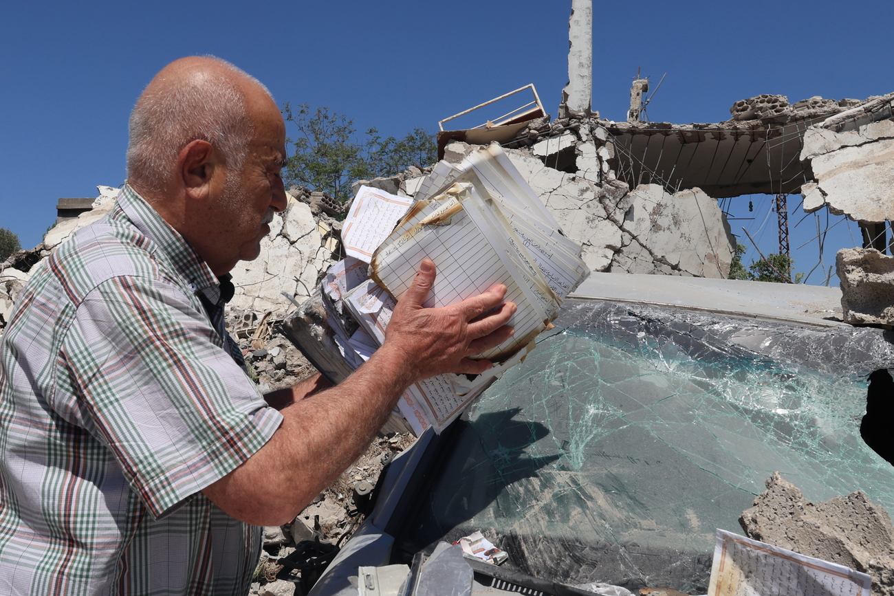 Man examines a destroyed house