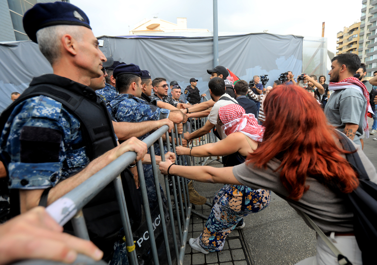 Protesters pull on police barricade