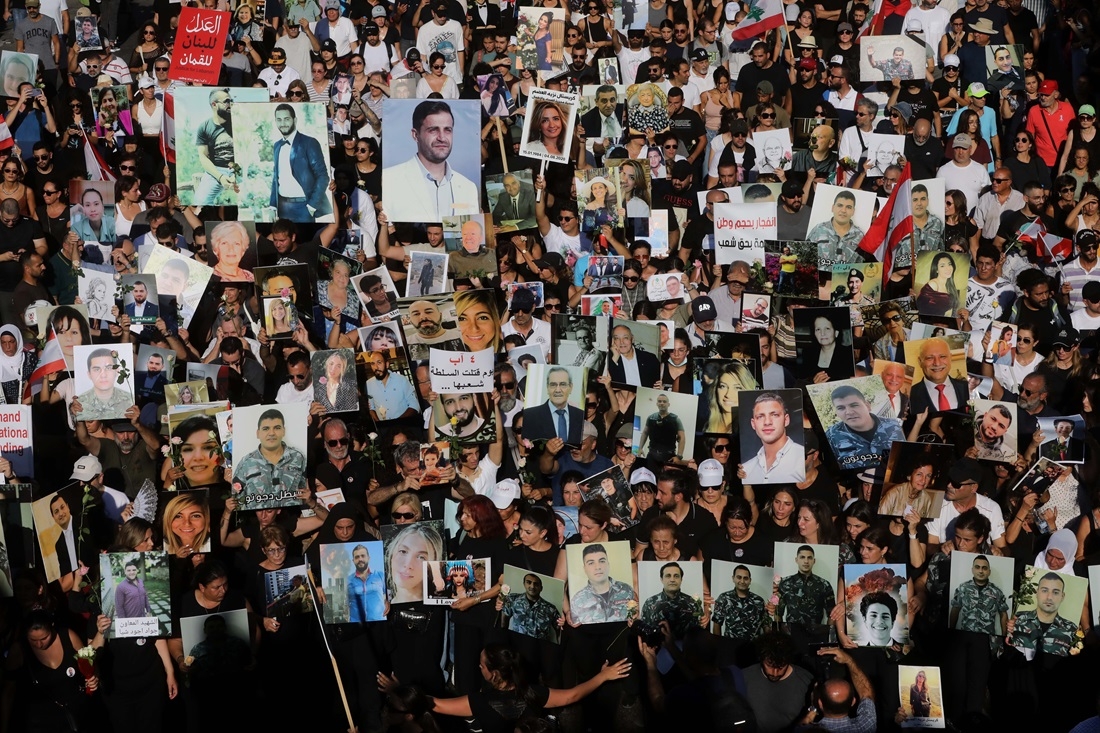 A large crowd of thousands of people walking together, carrying posters and photos.