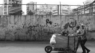 On the back wall of ‘Ibreen School, where working teenagers Mustafa and Hussein are standing, one reads the slogan “Love, Revolution, Anger” from a few years ago. Further to the middle of the image, the words “Jammul, the path to liberation, September 16, 1982” are inscribed.