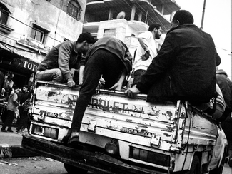 صورة بالأبيض والأسود لشاب يركب وسيلة نقل في منطقة العودة في رفح. مدينة رفح، قطاع غزة المحاصر. (مؤيد أبو أمونة، مصدر عام)