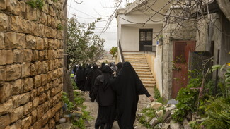 Grieving women, part of the funeral procession, navigate the narrow streets of the village. Houla, South Lebanon. March 6, 2024. (Fatima Joumaa/The Public Source)