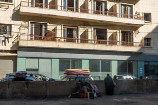 Two women, with the few belongings they managed to carry from their homes, sit outside the Hamra Star building after being threatened with eviction. Beirut, Lebanon. October 21, 2024. (Fatima Joumaa/The Public Source)