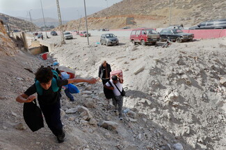 People cross the Masnaa border crossing with Syria on October 17, 2024. 