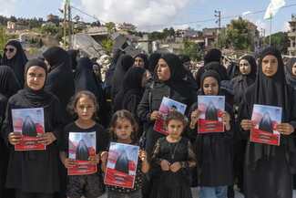 فتيات يحملن صور شهداء ميس الجبل الذين ارتقوا في ضربة الضاحية الجنوبية التي ادّعى العدو استهداف كبار قادة المقاومة الإسلامية ونتج عنها مجزرة مهولة. ميس الجبل، لبنان، ٢١ أيلول، ٢٠٢٤. (فاطمة جمعة/ مصدر عام)