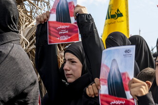 فتاة تحمل صورة شهيدة من ميس الجبل من الذين ارتقوا في ضربة الضاحية الجنوبية التي ادّعى العدو استهداف كبار قادة المقاومة الإسلامية ونتج عنها مجزرة مهولة. ميس الجبل، لبنان، ٢١ أيلول، ٢٠٢٤. (فاطمة جمعة/ مصدر عام)