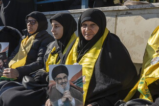 سيدة تحمل صورة الشهيد السيد حسن نصر الله في يوم تشييعه المهيب في المدينة الرياضية. ٢٣ شباط ٢٠٢٥.