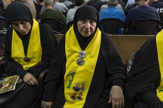 سيدة تضع شال حزب الله على كتفيها في التشييع المهيب للشهيدين السيد حسن نصر الله وهاشم صفي الدين في المدينة الرياضية. ٢٣ شباط ٢٠٢٥.
