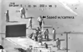 A black and white screenshot of footage of a helicopter firing at civilians in a square. The screenshot identifies one of the people in the still as "Saeed w/ camera"