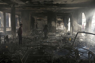 Children walk through the charred remains of what was once a school.