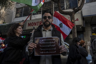 A survivor of the Israeli pagers attack participating in a protest. He carries a poster that reads: “It is on the state to shelter its own.”