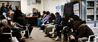 Town residents gather around the church hall with Father Maroun Ghafari. 