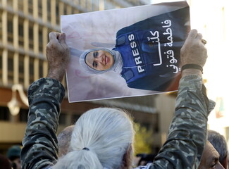 A protestor holds up a poster of late journalist Fatima Ftouni, whom Israel targeted and killed on March 28. The poster reads: “We are all Fatima Ftouni.”